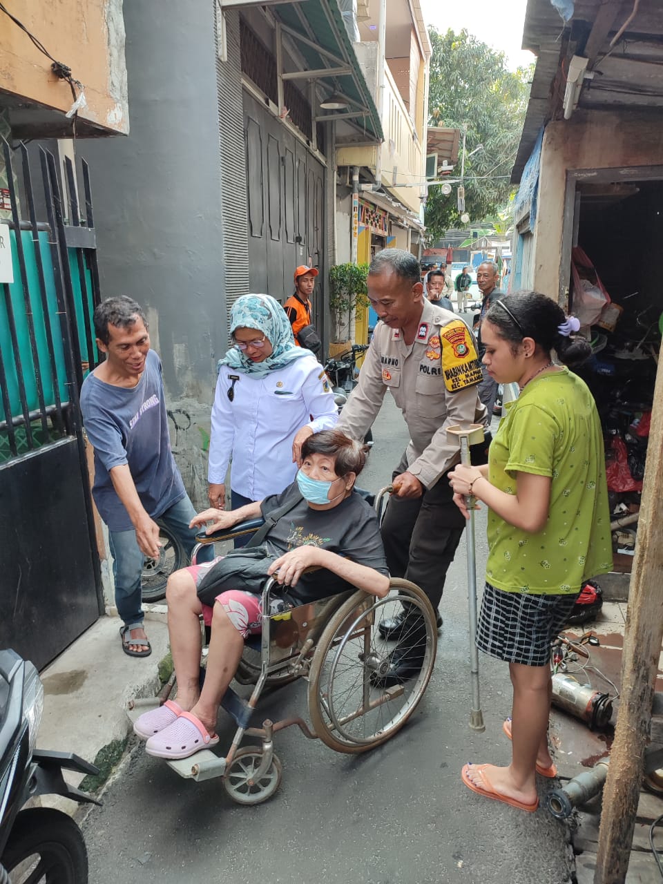 Read more about the article Aksi Peduli Warga Binaannya, Bhabinkamtibmas Kel Maphar Bantu Dorong Kursi Roda Warganya Yang Sakit